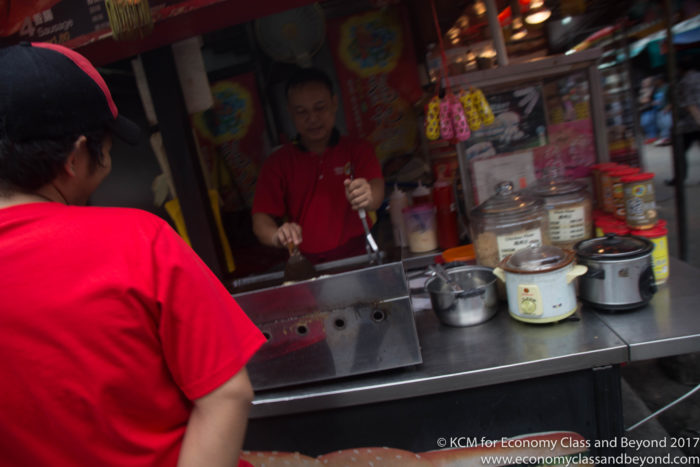 a man in red shirt cooking food
