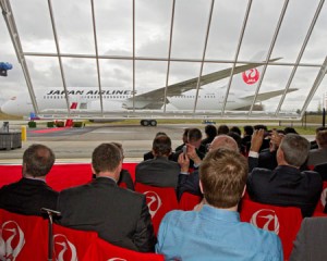 a group of people sitting in chairs looking at an airplane