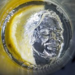 a silver head in a glass of water with a lemon slice