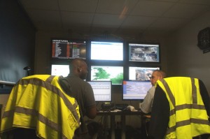 men wearing reflective vests sitting in front of computer screens