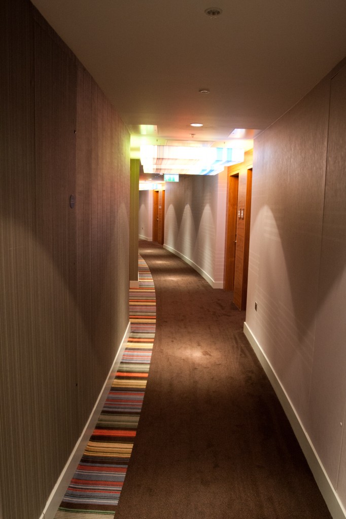 a long hallway with a striped carpet