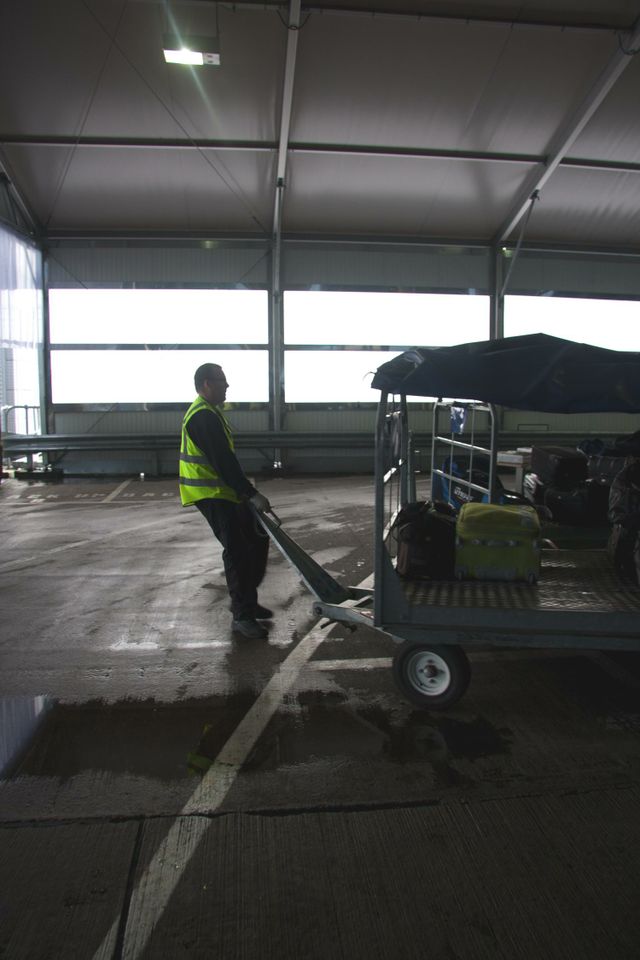 a man in a yellow vest pushing a cart