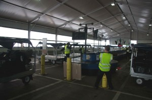men in a warehouse with luggage carts
