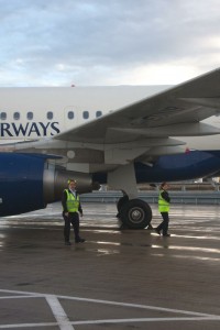 two men standing next to a plane