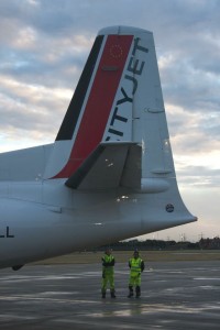 two men standing next to a plane