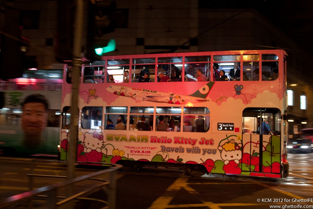 a pink double decker bus with people on it