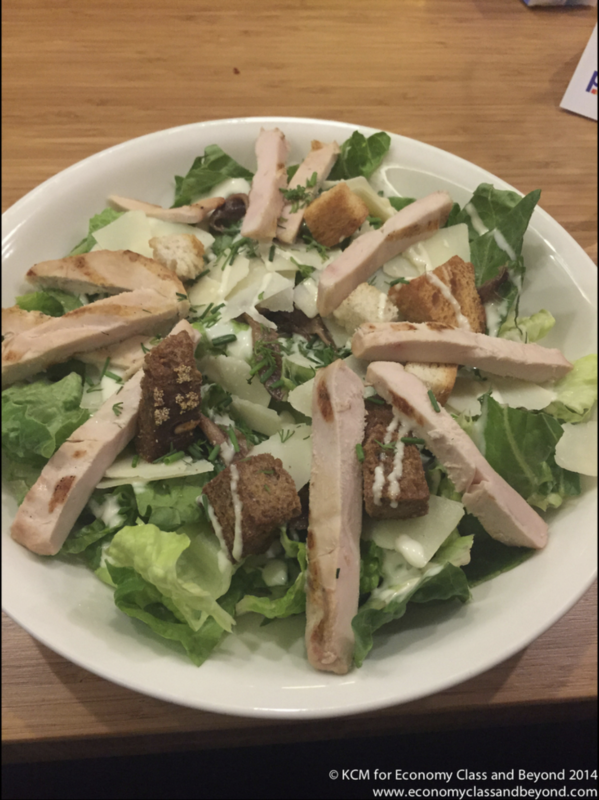 a plate of salad with meat and croutons