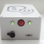 a white box with a red button and green lights