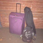 a purple suitcase next to a guitar case