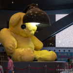 a large stuffed bear with a lamp on top of it