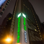 a tall building with green lights