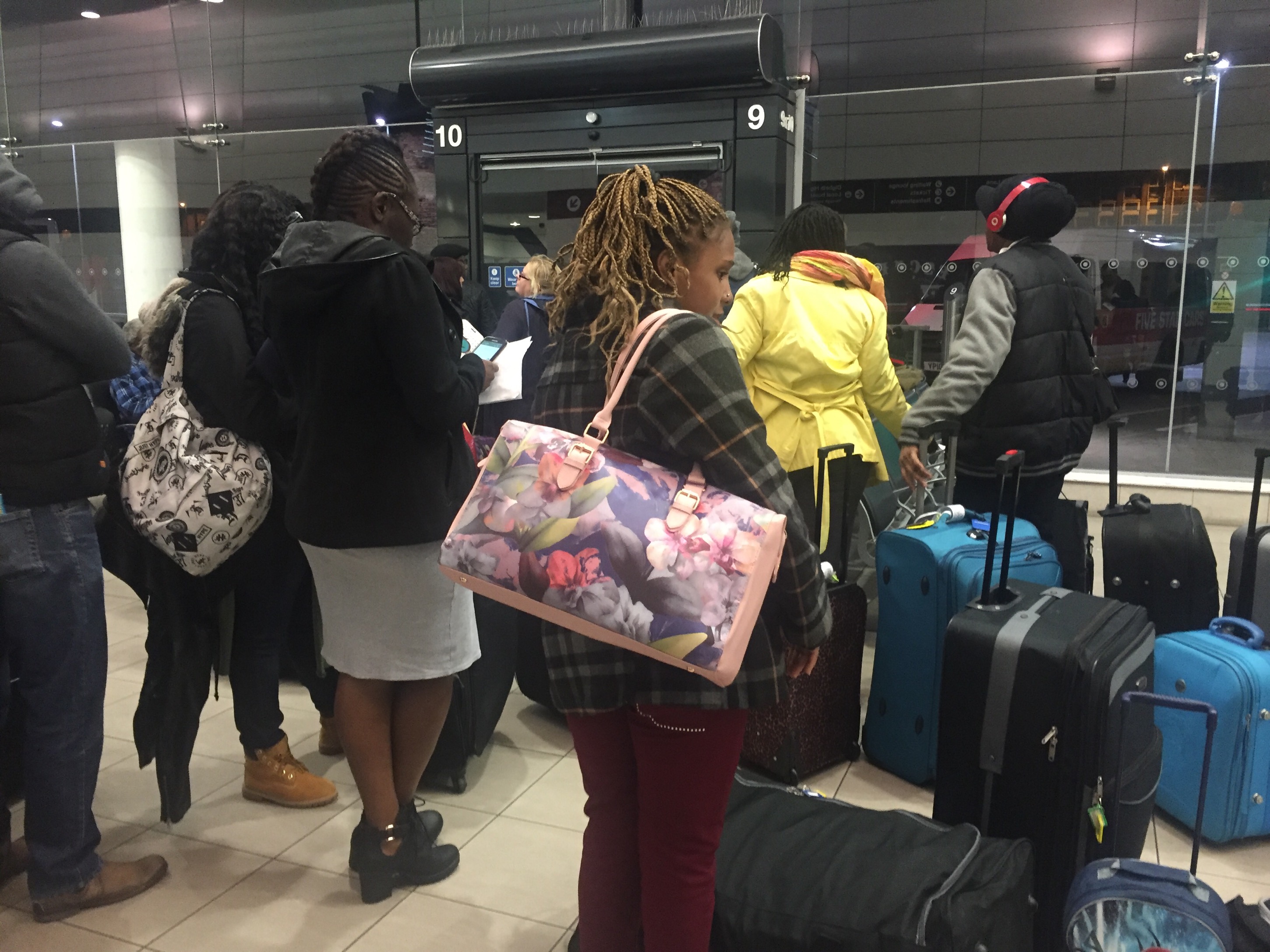 a group of people standing in a line with luggage