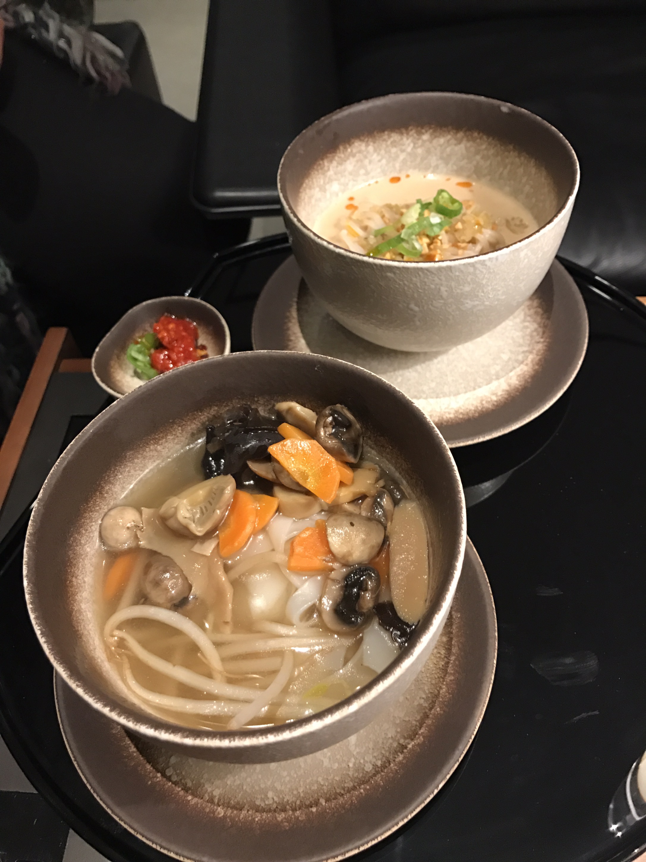 bowls of soup and noodles on plates