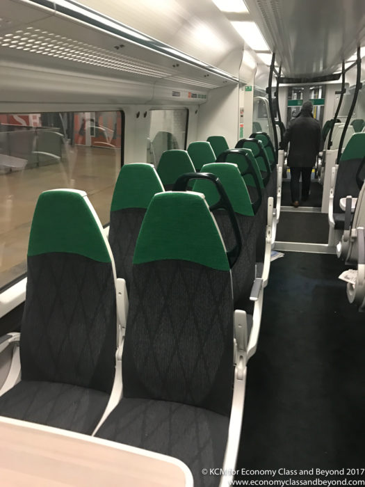 a train with seats and a person walking