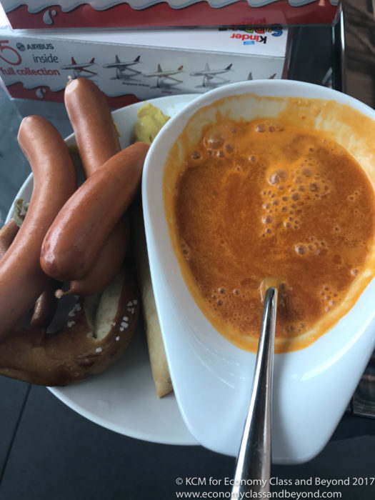 a bowl of soup and sausages on a plate