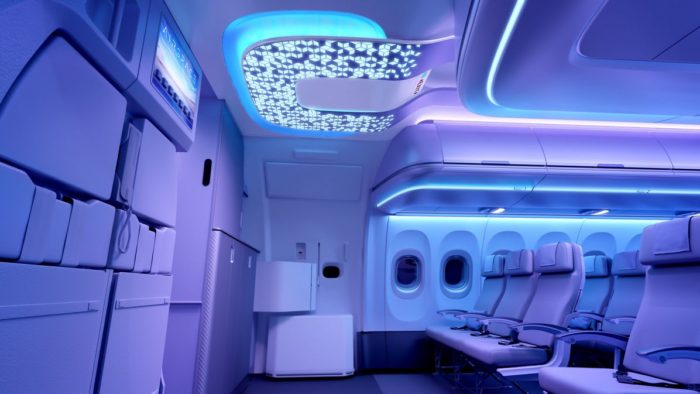 a interior of an airplane with seats and a tv