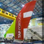 a red and green tail of an airplane in a hangar