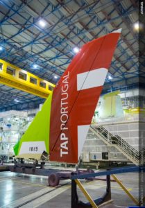 a red and green tail of an airplane in a hangar