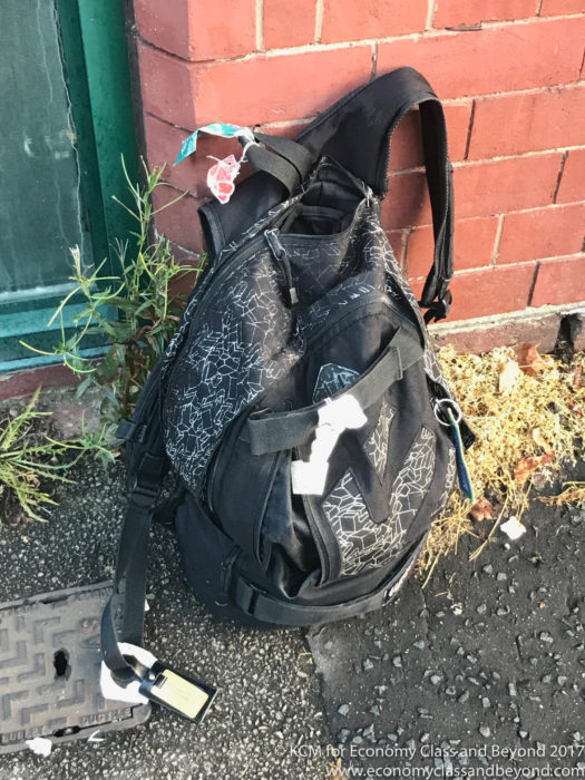 a backpack leaning against a brick wall