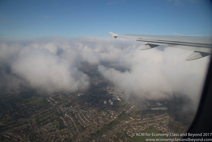 an airplane wing and clouds above a city