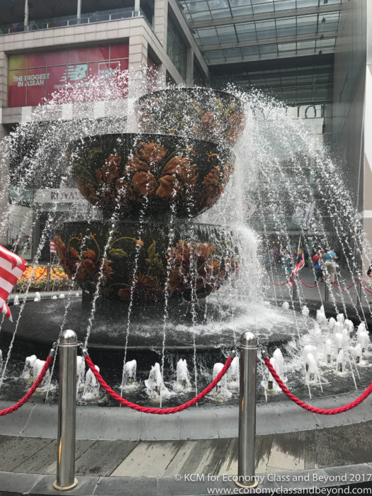 a water fountain with a flag in the background