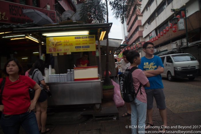 a group of people standing outside a food stand