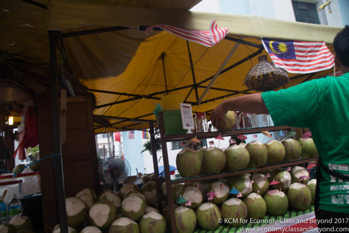 a man standing behind a display of coconuts