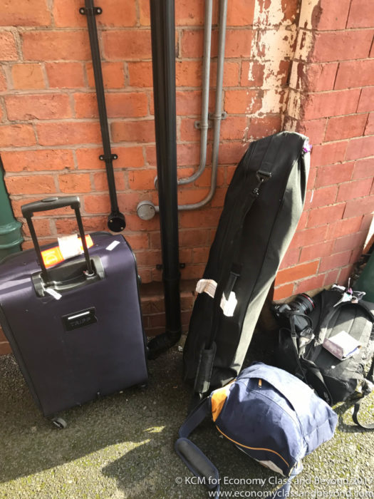 a group of luggage next to a brick wall