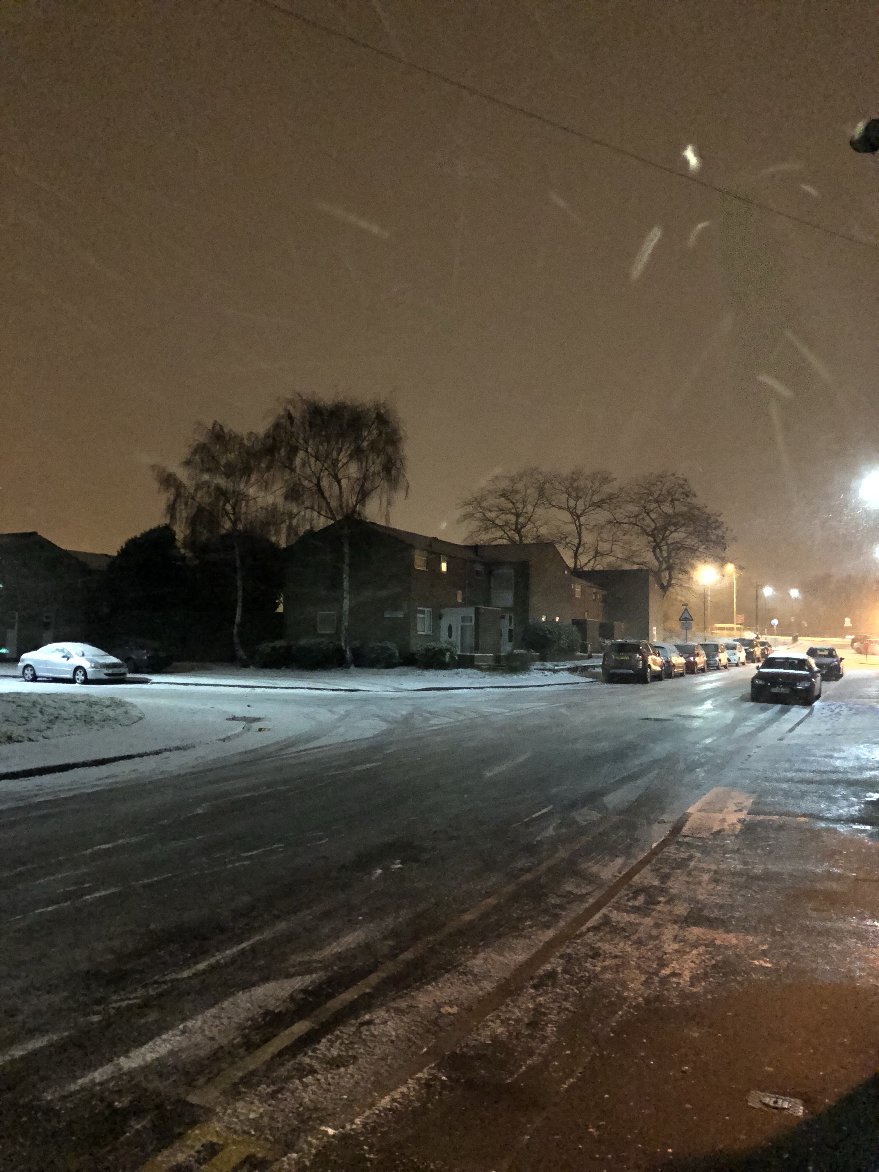 a snow covered street with cars and buildings