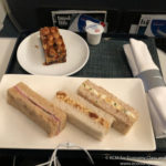 a plate of sandwiches and a dessert on a tray