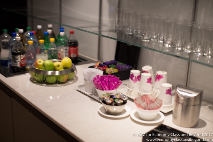 a counter with a variety of drinks and cups