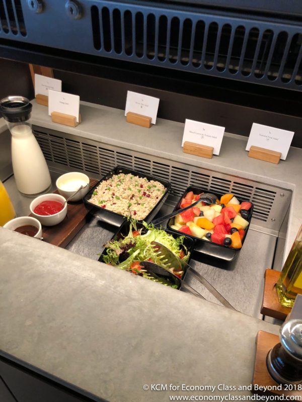 food in a tray with salads and other food on a counter