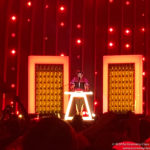 a man on a stage with a podium and lights