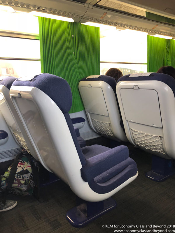 a group of people sitting in a train seat