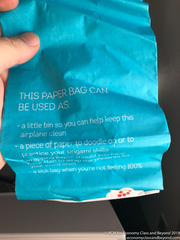 a hand holding a blue paper bag