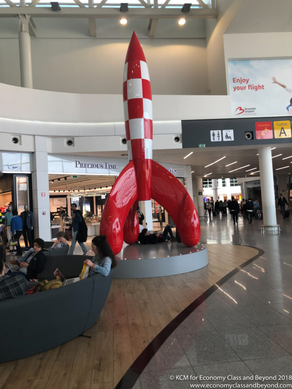 a red and white rocket statue in a mall