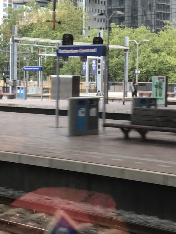 a train station with a bench and a sign