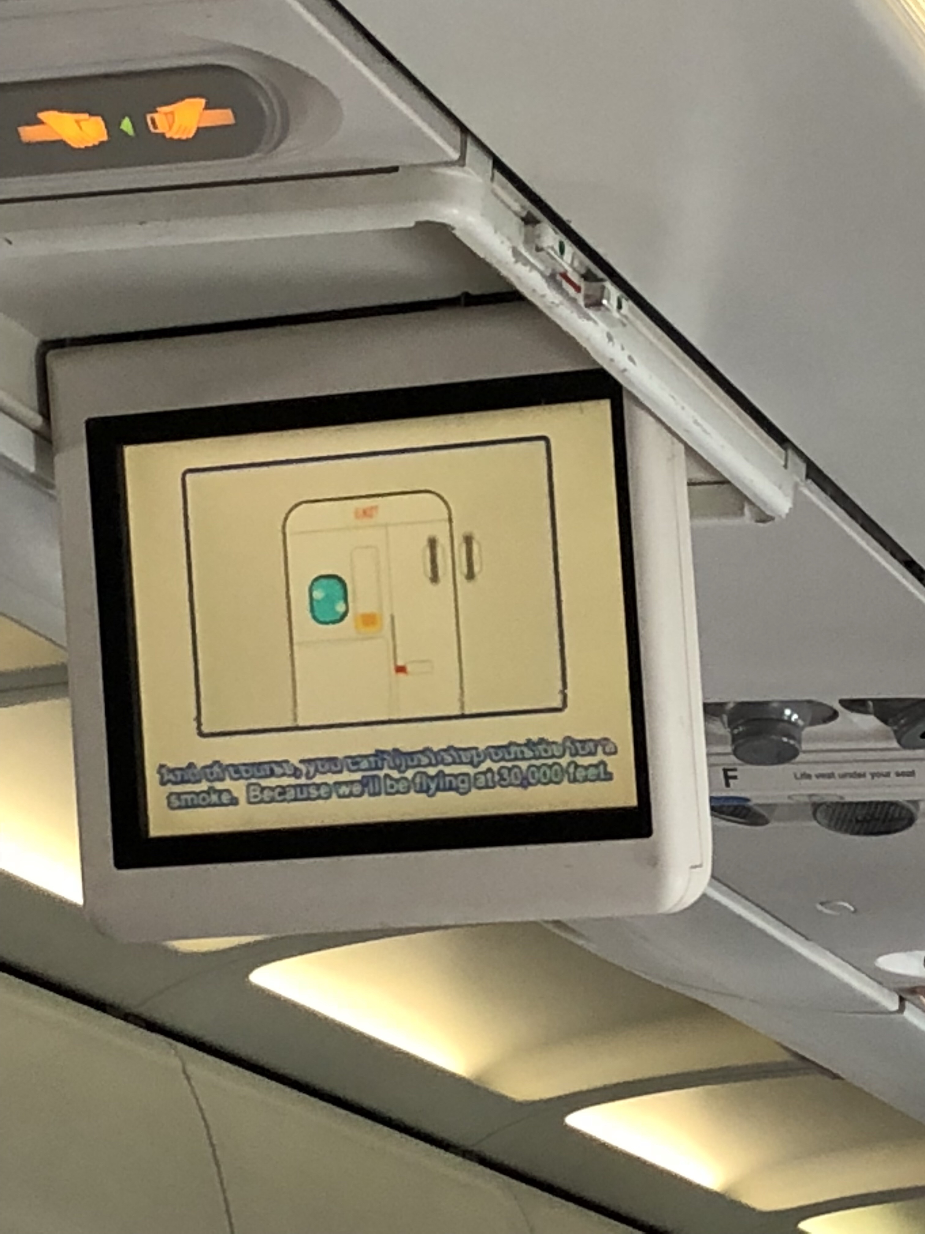 a screen on the ceiling of an airplane