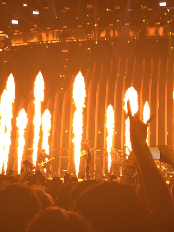 a group of people on a stage with fire in the background