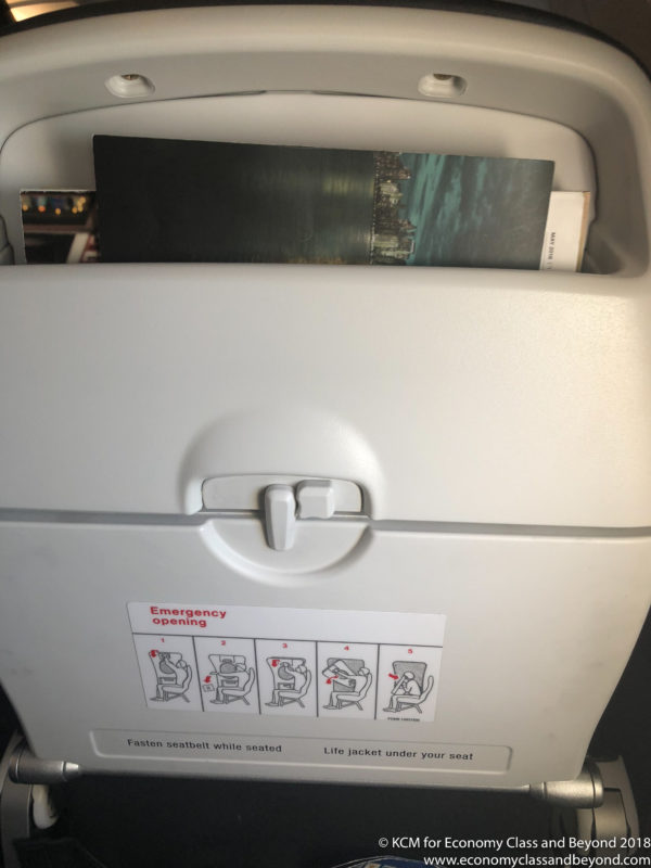 an airplane seat with a book in it