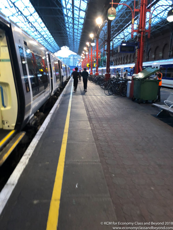 people walking on a platform with a train