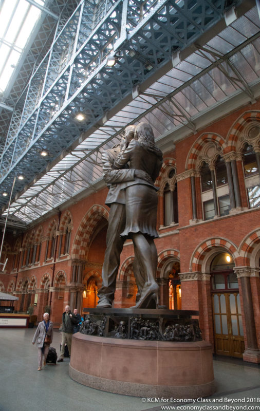 a statue of a man and woman in St Pancras railway station