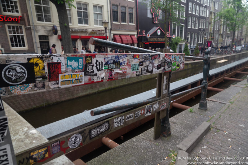 a canal with a railing with stickers on it