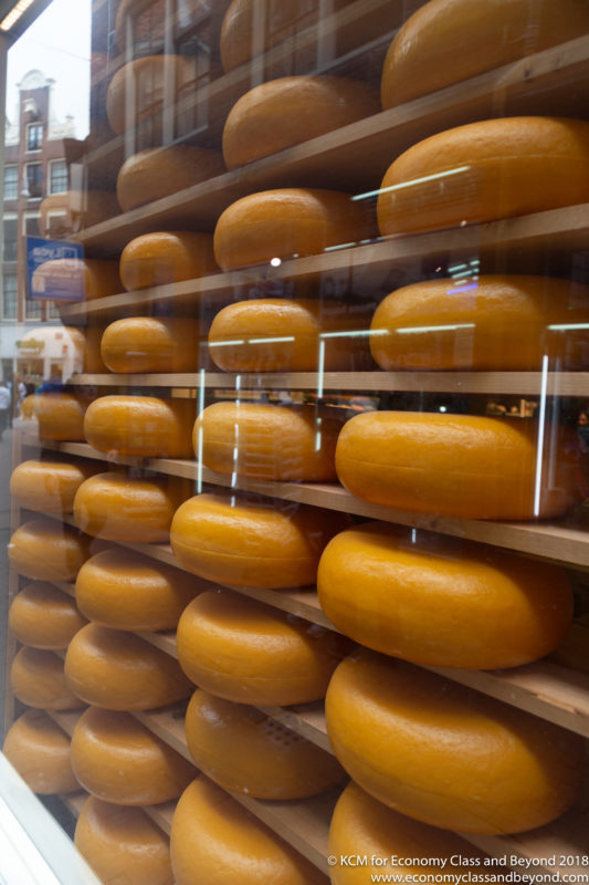 a stack of cheeses on shelves