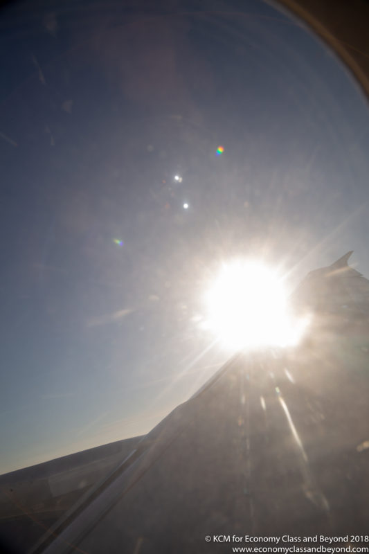 the sun shining through the window of an airplane