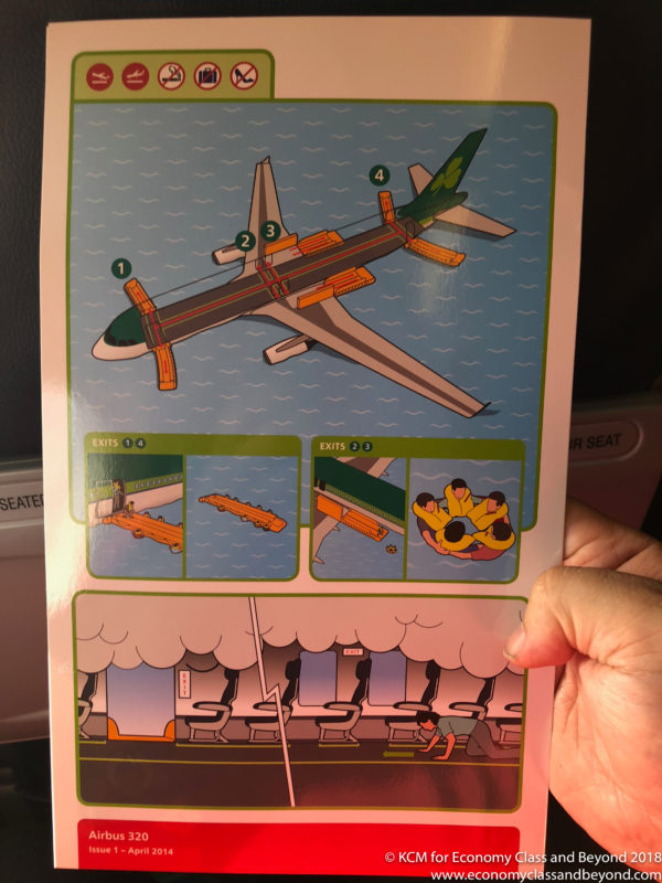 a hand holding a paper with an airplane and instructions