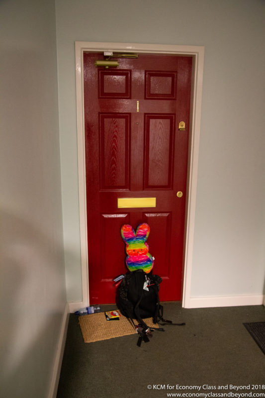 a red door with a backpack and a stuffed bunny
