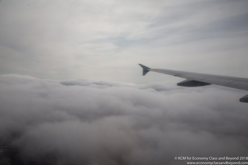 a wing of an airplane above clouds