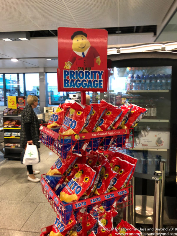 a red shopping cart with bags of chips on it