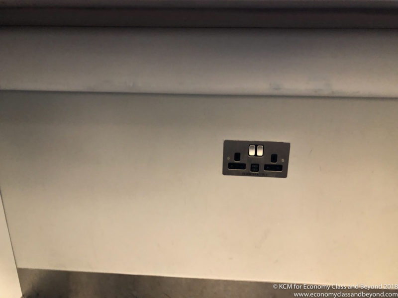 a wall with a silver outlet